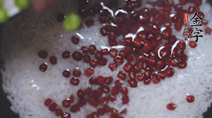 將炒好的食材和大米、紅豆一起放進(jìn)電飯鍋煮。