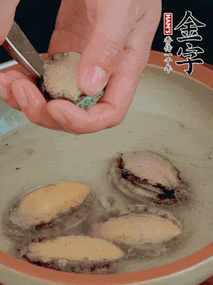 鮑魚加鹽、清水浸泡，用勺子挖出鮑魚肉。