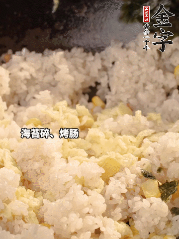剩米飯下鍋炒散，依次下玉米粒、雞蛋、烤腸、海苔碎翻炒均勻。